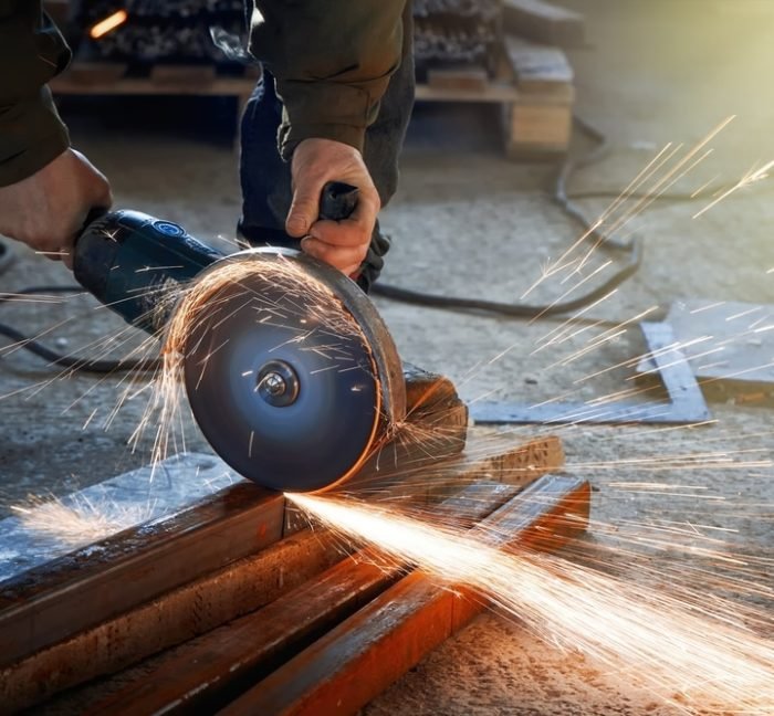 man cutting steel channel with circular saw