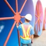 man inspecting roll of mild steel